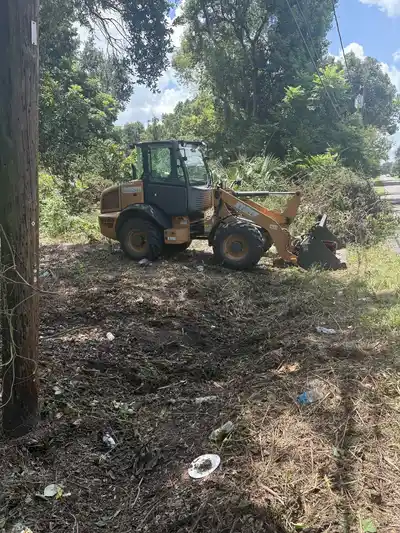 Heavy machinery used for lot clearing service in a wooded area.