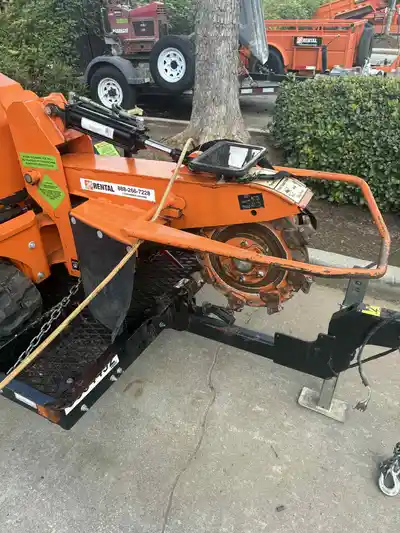 Close-up view of a stump grinding machine showing the cutting mechanism.