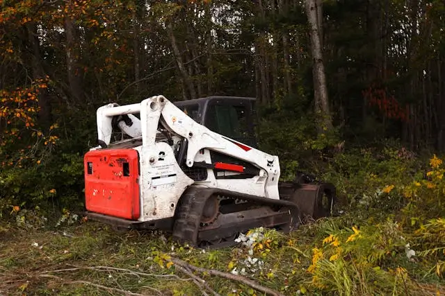 Heavy equipment for land clearing amidst fall foliage.
